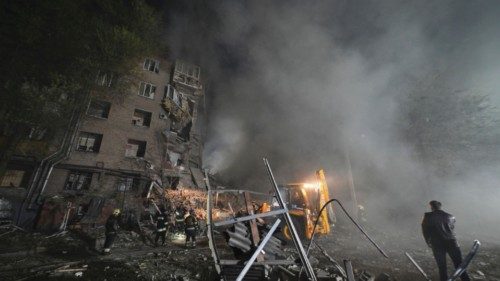 Rescuers work at a site of a residential building heavily damaged by a Russian missile strike, amid ...