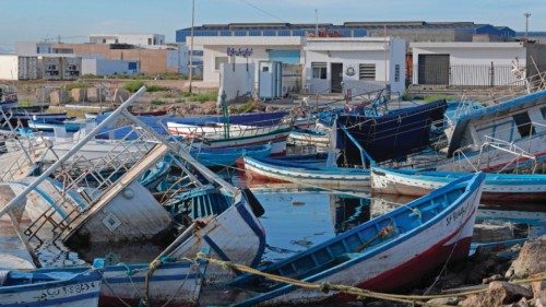 Piles of captured migrant boats are seen at the port of the central Tunisian city of Sfax, on ...