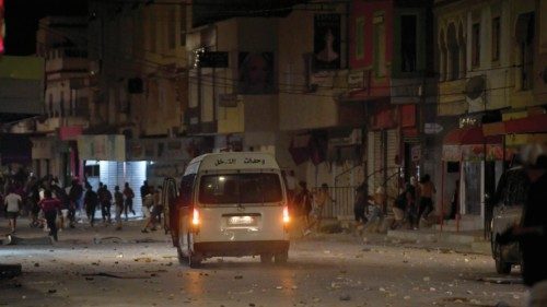 A police vehicle is stationed in the middle of street during protesters in Ettadhamen, a ...