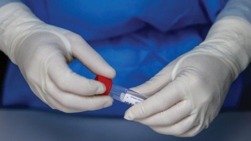 epa10242912 A health worker holds a vial at a COVID-19 test site for journalists at the Xiyuan Hotel ...