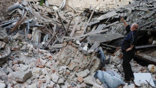 A local resident takes pictures of a building heavily damaged by a Russian missile strike, amid ...