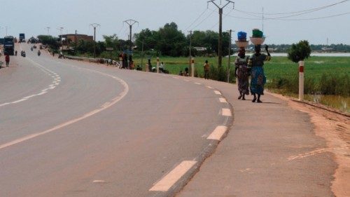 Two women from Gaya walk toward the bridge crossing the Niger river between Niger and Benin to sell ...