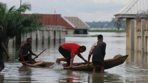 Victoria Okonkwo enters a canoe on a flooded street close to the bank of Benue River in Makurdi, ...