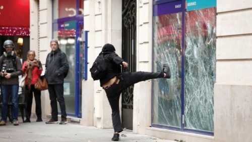 A demonstrator destroys a bank window during clashes at a demonstration in Paris as part of a ...