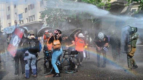 TOPSHOT - Demonstrators are sprayed with water cannons during clashes with riot police which erupted ...