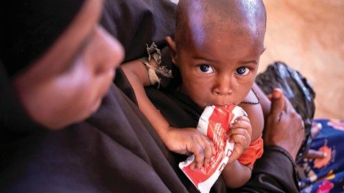 On 3 February 2022 in Somalia, a child feeds on a Ready-to-Use Therapeutic Food (RUTF) packet while ...