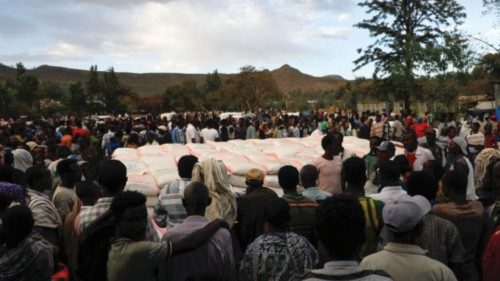 FILE PHOTO: People stand in line to receive food donations, at the Tsehaye primary school, which was ...