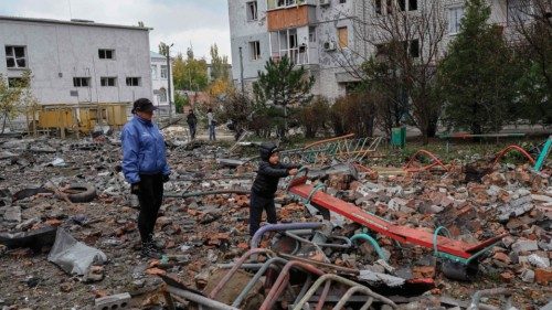 A children tries to play in the middle of rubbles as his mother stands next to him  after a rocket ...