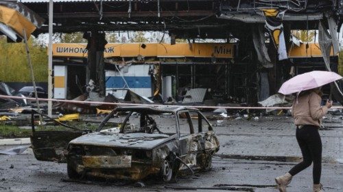 A woman passes by a gas station destroyed by yesterday's Russian military strike, as Russia's attack ...