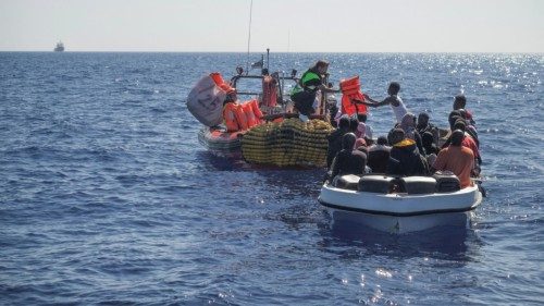 Crew members of NGO rescue ship 'Ocean Viking' give lifejackets to migrants on an overcrowded boat ...