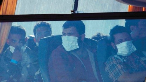 Migrants sit inside a bus after disembarking from the Italian Coast Guard's patrol vessel Diciotti ...