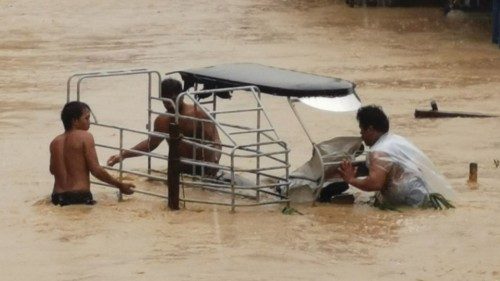 People wade through flood water due to tropical storm Nalgae in Boac, Marinduque, Philippines ...