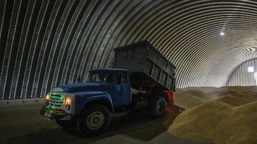 FILE PHOTO: An employee unloads wheat grains inside a storage in the village of Zghurivka, amid ...