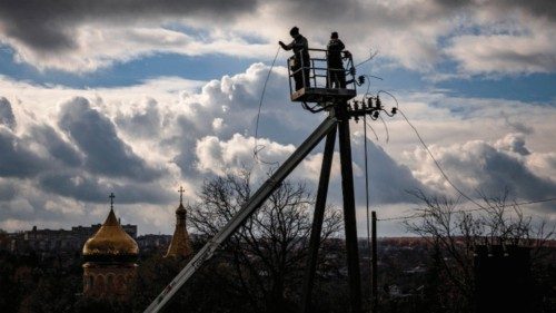 TOPSHOT - Communal workers repair power lines cut by shelling in the town of Kupiansk, Kharkiv ...