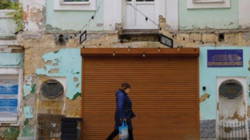 A woman walks along a street on an autumn day, in the course of Russia-Ukraine conflict in the city ...