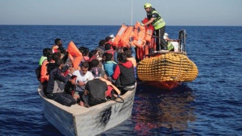 Crew members of NGO rescue ship 'Ocean Viking' give lifejackets to migrants on an overcrowded boat ...