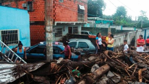 Residents remain among the rubble of destroyed houses caused by a landslide after heavy rains in the ...