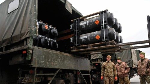 (FILES) In this file photo taken on February 11, 2022 Ukrainian servicemen load a truck with the ...