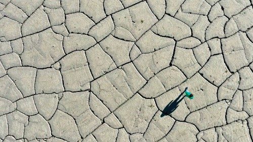 TOPSHOT - An aerial picture shows a man walking on the dried-up bottom of the Banja hydro-power ...