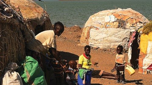 A family of El-molo community sit outside their new makeshift house after being forced to relocate ...