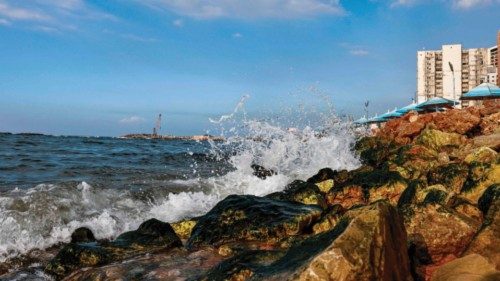 Waves crash along the concrete blocks installed to break them along the Mediterranean sea waterfront ...