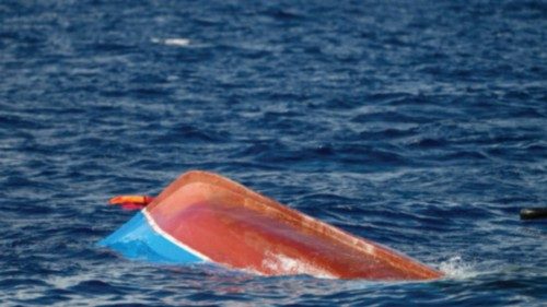 A overturned wooden boat used by migrants sinks after a rescue operation by Spanish NGO Open Arms ...