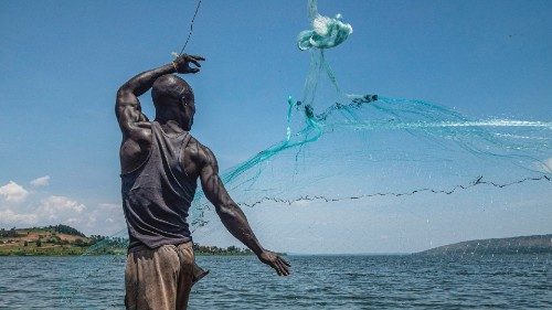 This photograph taken on October 7, 2022, shows Jowali Kitagenda, 40, casting his net to catch fish ...
