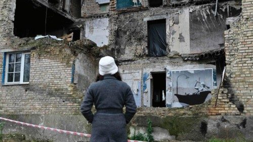 A woman looks at a graffiti made by Banksy on the wall of a heavily damaged building in the Gorenka ... A woman looks at a graffiti made by Banksy on the wall of a heavily damaged building in the Gorenka ...