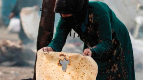 A displaced Syrian woman makes bread at the Sahlah al-Banat camp for displaced people in the ...