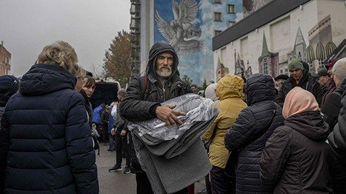 People take blanket and light during an aid supply distribution in the centre of Kherson on November ...