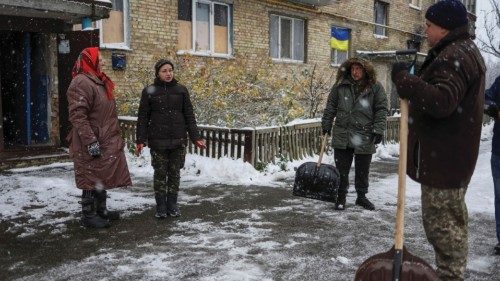 Local resident Tetiana Reznychenko, 43, speaks with her neighbours near her destroyed building, ...