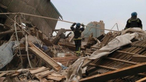 Rescuers clear debris of the destroyed two-storey maternity building in the town of Vilnyansk, ...