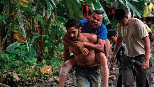 Venezuelan migrant Jesus Arias is helped by a friend as they arrive at Canaan Membrillo village, the ...