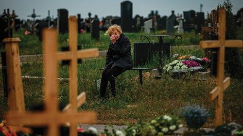 TOPSHOT - A woman mourns while visiting the grave of Stanislav Hvostov, 22, a Ukrainian serviceman ...