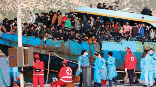 Hellenic Red Cross rescuers and health workers stand by a boat carrying some 400 refugees and ...