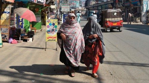 In this picture taken on October 25, 2022, women walk along a road in a market area of Mingora in ...