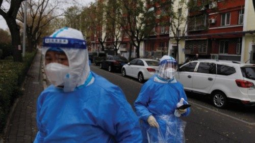 Men in protective suits walk in the street as outbreaks of coronavirus disease (COVID-19) continue ...