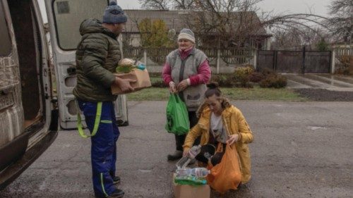 epa10331722 Andriy Kiselyov (L), a volunteer, delivers humanitarian aid to local people at a ...