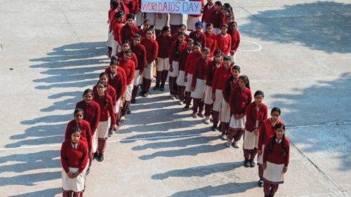 School students pose for a photograph as they stand in the shape of a ribbon as part of an awareness ...