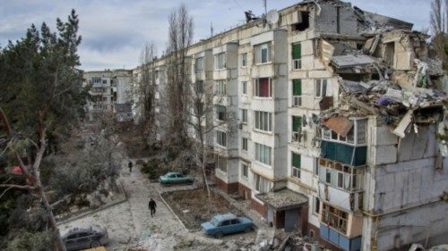 epa10344318 Ukrainian rescuers work on a building that was destroyed during night shelling in the ...