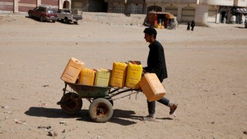 epa10325350 A Yemeni pushes a wheelbarrow with empty jerrycans before filling them with water from a ...