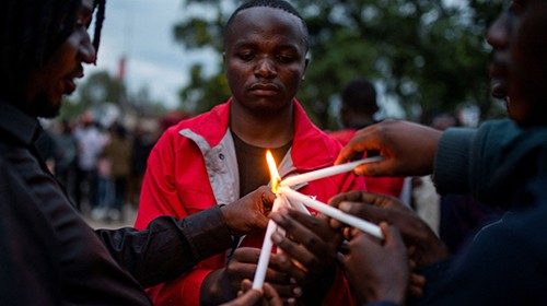 Congolese activists light candles during a vigil in memory of the civilians killed in the recent ...
