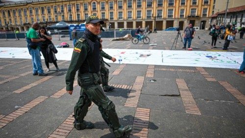 A member of the Colombian riot police walks next to a banner during a ceremony to celebrate six ...