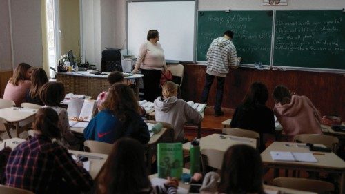 Students attend a lesson of English language in a classroom at a school, amid Russia's attack on ...