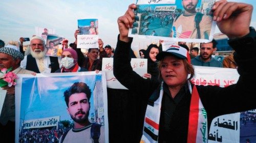 Iraqi demonstrators lift placards calling for the release of activist Haidar al-Zaidi, who was given ...