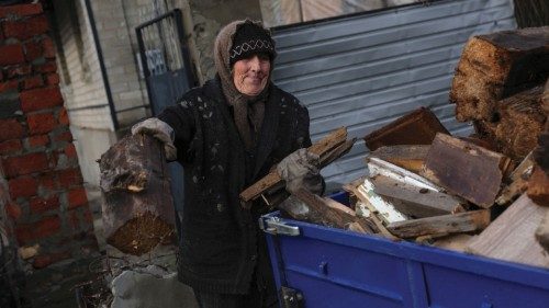 A woman loads fire wood, as Russia's attack on Ukraine continues, in the formerly Russian occupied ...