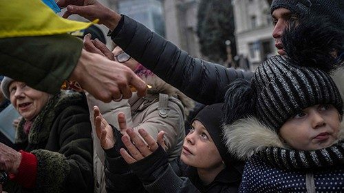 TOPSHOT - A child receives aid supplies in the centre of Kherson on November 18, 2022, amid the ...