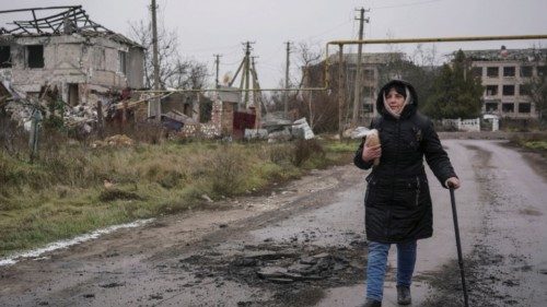Local resident Oksana Oliinyk, 62, holds bread as she walks near destroyed buildings, as Russia's ...