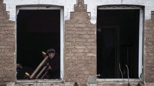 A local resident Natalia, 67, is seen in a window her house destroyed by a Russian military strike, ...