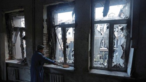 A woman removes broken glass inside a hospital damaged by recent shelling in the course of ...